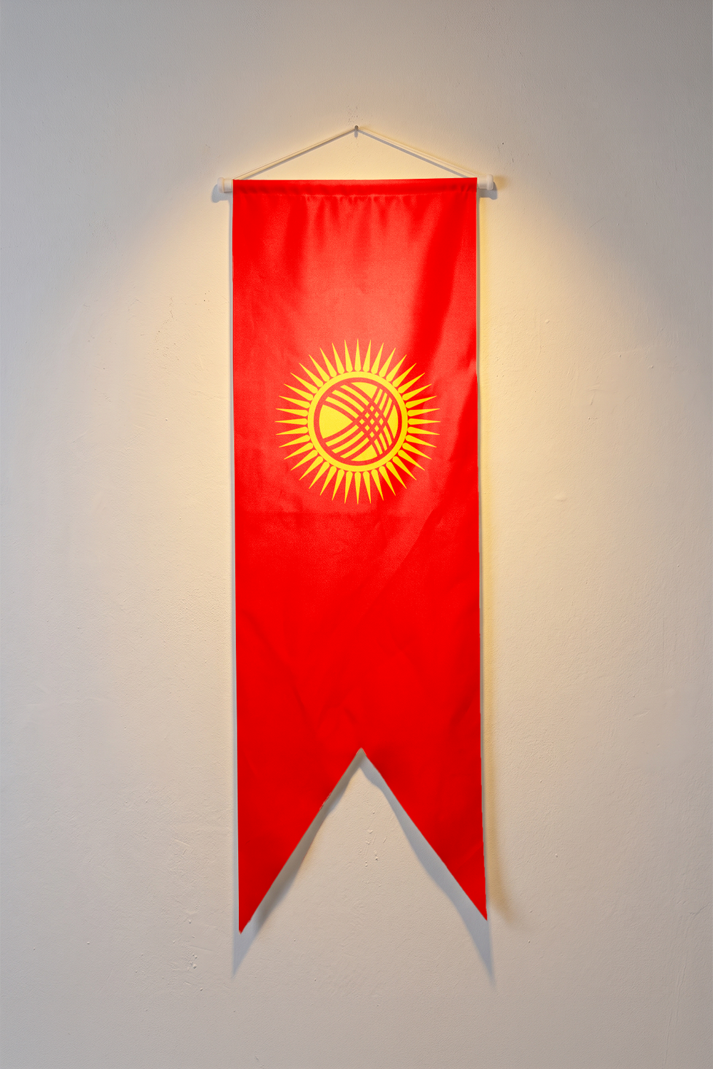 Kırgızistan Bayrağı, kırmızı zemin üzerindeki sarı güneş ve merkezindeki çizgisel motif, V kesim kırlangıç flama